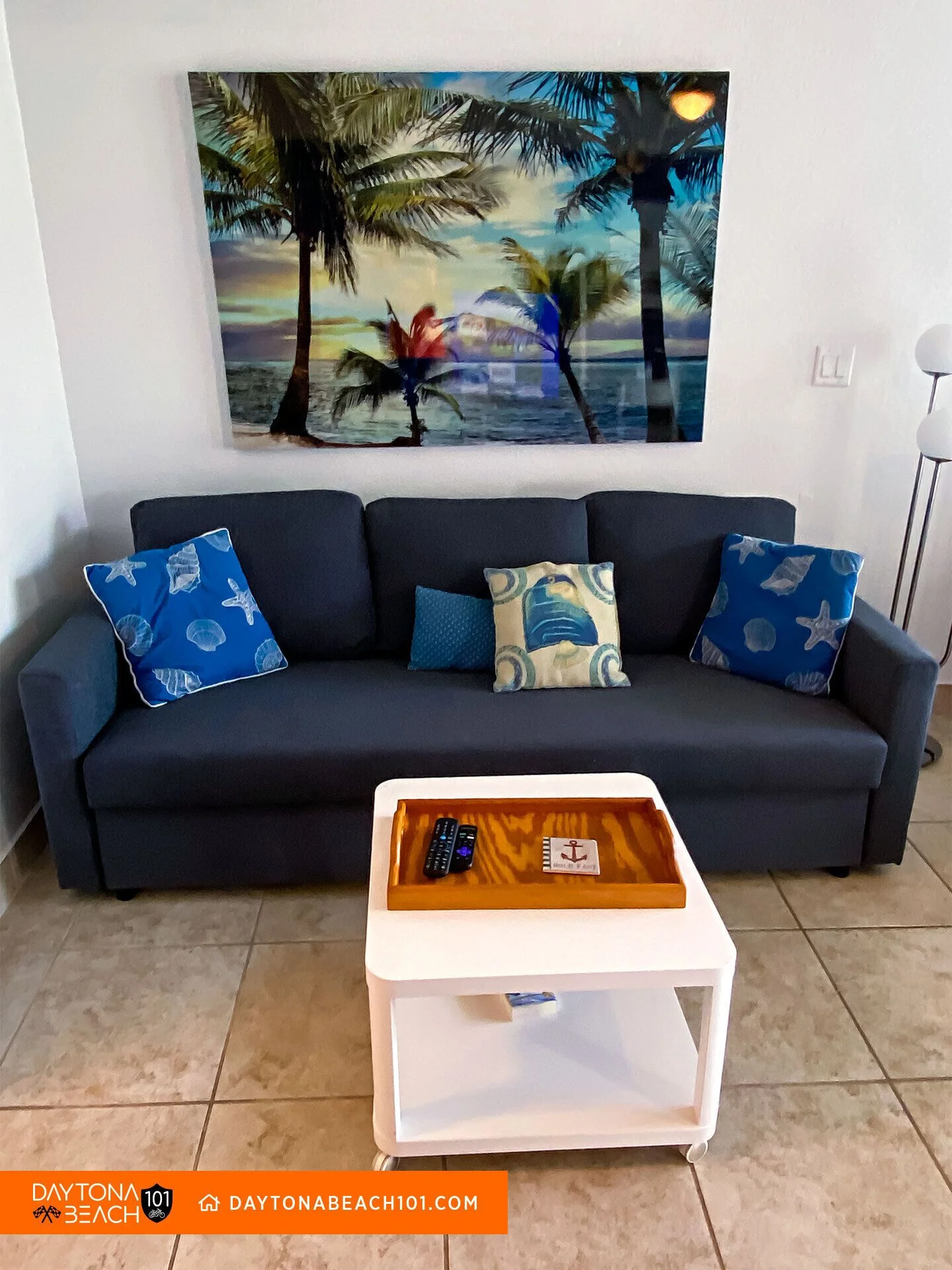 Oceanfront living room with dark navy sofa and coastal decor at a Daytona Beach vacation rental