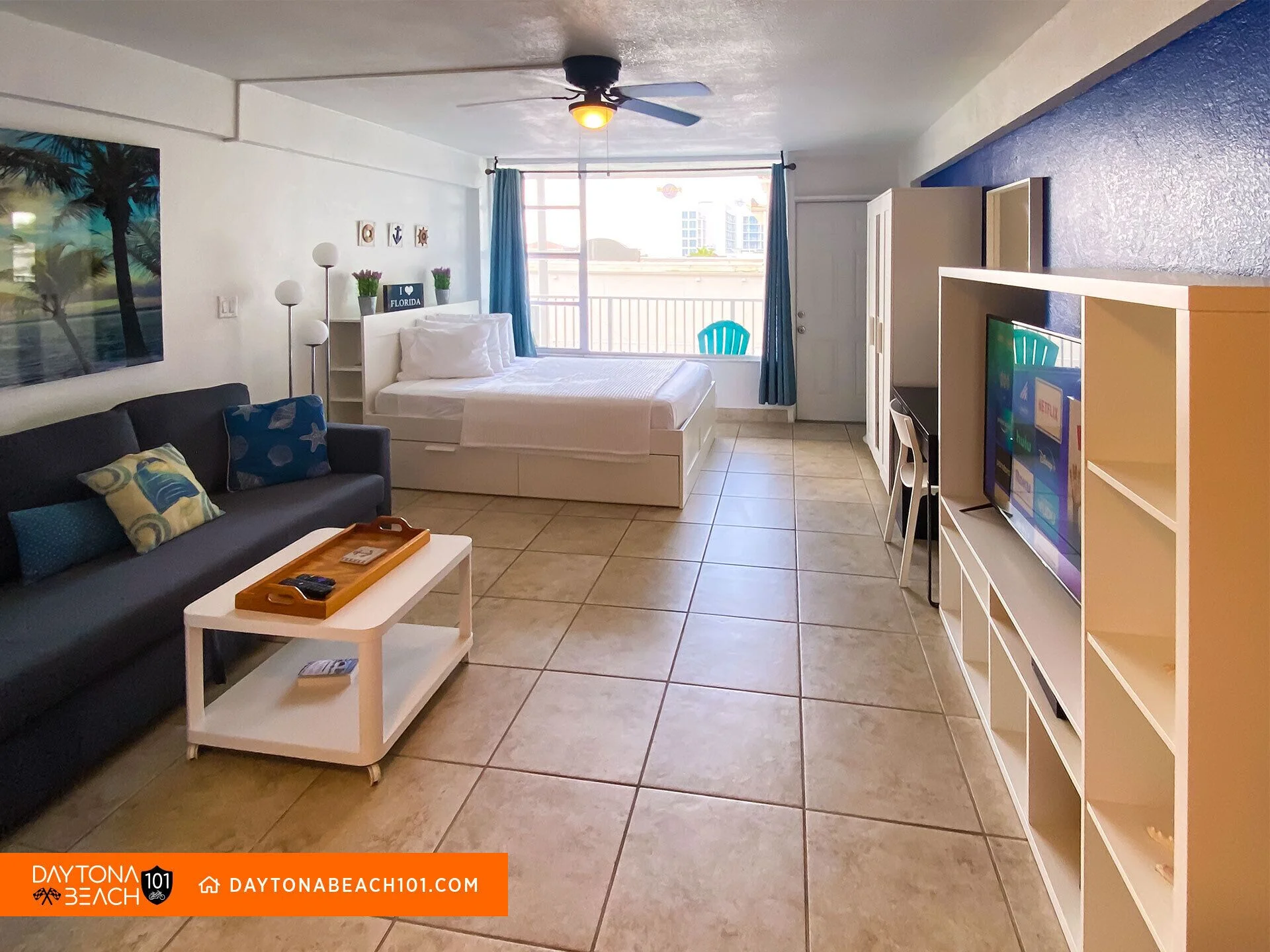 Studio living room with ocean view balcony and king bed in Daytona Beach vacation rental
